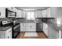 Modern kitchen with white cabinets, granite countertops, stainless steel appliances, and stylish backsplash, offering a sleek design at 469 Ash Dr, Carmel, IN 46032