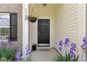 Inviting front entrance with a black door, colorful flower baskets, and brick and vinyl siding at 5145 Greenside Dr, Indianapolis, IN 46235