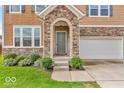 Close-up of the front door showcasing the stone archway, welcoming entrance, and manicured landscaping at 532 Amersham Ct, Avon, IN 46123