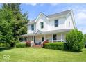 Inviting two-story home with a charming wrap-around porch, manicured lawn, and mature landscaping at 5480 E County Rd 800 N, Brownsburg, IN 46112