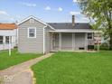 View of the home's rear exterior with a covered porch and green lawn at 618 Miller Ave, Shelbyville, IN 46176