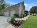 Brick home featuring a two-car garage, concrete driveway, and manicured landscaping at 6693 W May Apple Dr, McCordsville, IN 46055