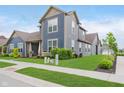 Two-story home featuring blue siding, a well-manicured lawn, and a clean, modern exterior design at 7077 Antiquity Dr, Carmel, IN 46033