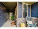 Inviting front porch with a rocking chair, decorative stool, and a welcoming sunflower door mat at 7077 Antiquity Dr, Carmel, IN 46033