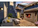 Cozy outdoor patio features a brick fireplace, comfortable seating, and string lights, creating a warm and inviting ambiance at 7077 Antiquity Dr, Carmel, IN 46033
