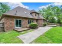 Brick home with a spacious backyard, a small deck, and a concrete walkway at 7513 Pine Royal Dr, Indianapolis, IN 46256