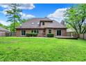 View of the home's backyard with a grassy yard and a small wood deck at 7513 Pine Royal Dr, Indianapolis, IN 46256