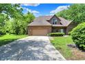 Well-maintained brick home with an attached garage, large driveway, and neatly landscaped front yard at 7513 Pine Royal Dr, Indianapolis, IN 46256