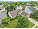 Aerial shot of a home with a lush green lawn and a tranquil lake nearby, providing a scenic view at 7970 Cobblesprings Dr, Avon, IN 46123