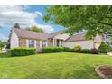 Charming single-story home with brick accents and a well-manicured lawn under a blue sky at 7970 Cobblesprings Dr, Avon, IN 46123