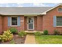Close up on the entrance to a brick home with a well maintained yard and blue shutters at 9159 E County Road 400 N, Brownsburg, IN 46112
