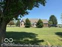 Expansive backyard with well-maintained lawn, mature trees, and a partial view of the home's rear at 916 N County Road 500 E, Avon, IN 46123