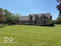 Beautifully landscaped front yard featuring a lush lawn and mature trees around the house at 916 N County Road 500 E, Avon, IN 46123