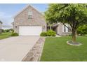 Charming brick home with a two-car garage, lush lawn, and inviting curb appeal at 9598 N Mariners Crst, McCordsville, IN 46055