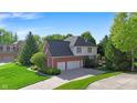 Rear exterior view of home with three-car garage, lush lawn and basketball hoop at 10390 Tremont Dr, Fishers, IN 46037