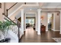 Inviting foyer featuring hardwood floors, white staircase, and views into living spaces at 10390 Tremont Dr, Fishers, IN 46037
