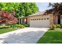 Beautiful home featuring lush landscaping, brick detailing, and a convenient two-car garage at 1045 Millwood Ct, Indianapolis, IN 46260