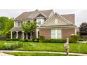 Beautiful two-story home with brick and siding, a covered porch, manicured lawn, and a mailbox at 11674 Timken Ct, Fishers, IN 46037