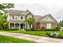 Beautiful two-story home with brick and siding, covered porch, well-manicured lawn, and a driveway at 11674 Timken Ct, Fishers, IN 46037