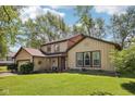 Attractive home with lush green lawn, mature trees, and pleasing curb appeal at 11733 East 21St St, Indianapolis, IN 46229