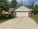 Traditional home featuring a two-car garage and a well-maintained front lawn at 12301 Winding Creek Cir, Indianapolis, IN 46236