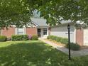 Charming single story home with lush lawn, manicured hedges and brick accents on a tree lined street at 12301 Winding Creek Cir, Indianapolis, IN 46236