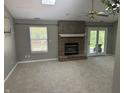 Cozy living room with a skylight, brick fireplace, and access to the backyard through glass doors at 12301 Winding Creek Cir, Indianapolis, IN 46236