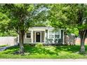 Charming home exterior framed by lush trees, showcasing a welcoming front porch and inviting curb appeal at 1342 N Oakland Ave, Indianapolis, IN 46201
