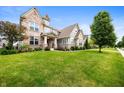 Charming home featuring a lush green lawn and professionally landscaped front yard at 15580 Garrano Ln, Fishers, IN 46040