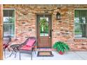 Close-up of a welcoming front door with wreath, flanked by windows and seating at 1649 Woodstock Dr, Brownsburg, IN 46112