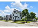 Charming two-story home with a black fence, black framed windows, and a beautifully shaded front yard at 19 E Regent St, Indianapolis, IN 46225