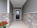 Charming front porch with stone accents and a black front door at 19657 Astoria Ave, Sheridan, IN 46069