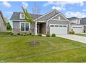Attractive home features a well-manicured lawn, a two-car garage, and a tasteful stone facade at 19657 Astoria Ave, Sheridan, IN 46069