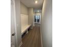 Hallway featuring wood floors, a coat rack, and decorative doors at the end at 2263 S Carlota Dr, New Palestine, IN 46163