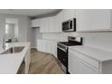 Modern kitchen with white cabinets, stainless appliances, and wood floors at 2693 Penn Ave, Plainfield, IN 46168