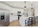 Bright kitchen featuring white cabinets, stainless steel appliances, and a large island with bar seating at 2693 Penn Ave, Plainfield, IN 46168