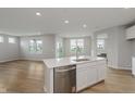 Open kitchen with white cabinets, an island, stainless appliances, and wood flooring at 2693 Penn Ave, Plainfield, IN 46168
