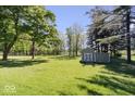 Spacious backyard with lush green grass, mature trees, and storage shed at 305 N 1100 E, Zionsville, IN 46077