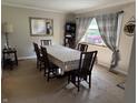 Traditional dining room featuring a long table for 6, neutral decor and a view to the front yard at 309 Arlington Dr, Whiteland, IN 46184
