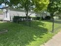 View of the home's side exterior and the front yard with a chain-link fence surrounding the property at 3161 Compass Dr, Franklin, IN 46131