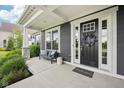 Inviting front porch with seating and a decorative wreath on the front door at 3316 Shelborne Woods Pkwy, Carmel, IN 46032