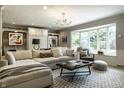 Cozy living room with bay window, comfortable seating, and modern lighting fixture at 410 Somerset W Dr, Indianapolis, IN 46260