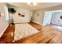 Bright living room with beautiful hardwood floors, a modern rug, and neutral paint at 4714 Crestview Ave, Indianapolis, IN 46205