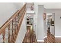 Spacious foyer with hardwood floors, a staircase with wooden banister, and views into the living areas at 4818 Arabian Run, Indianapolis, IN 46228