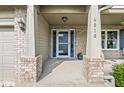 Close-up of the front porch with brick columns, house number, and blue door at 4818 Arabian Run, Indianapolis, IN 46228