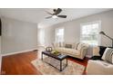Cozy living room with hardwood floors, modern furniture, a ceiling fan and ample natural light at 5232 E 10Th St, Indianapolis, IN 46219