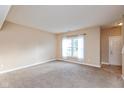 Neutral-toned living room featuring new carpet and a bright window with white curtains at 5891 Mimosa Dr, Indianapolis, IN 46234