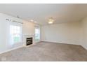 Spacious living room featuring new carpet, a fireplace, and natural light from large windows at 5891 Mimosa Dr, Indianapolis, IN 46234