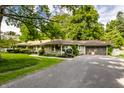 Ranch-style home with a two-car garage, stone facade, and well-maintained lawn at 6220 Spring Mill Rd, Indianapolis, IN 46260