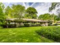 Beautiful ranch style home featuring a lush green lawn and mature landscaping at 6220 Spring Mill Rd, Indianapolis, IN 46260